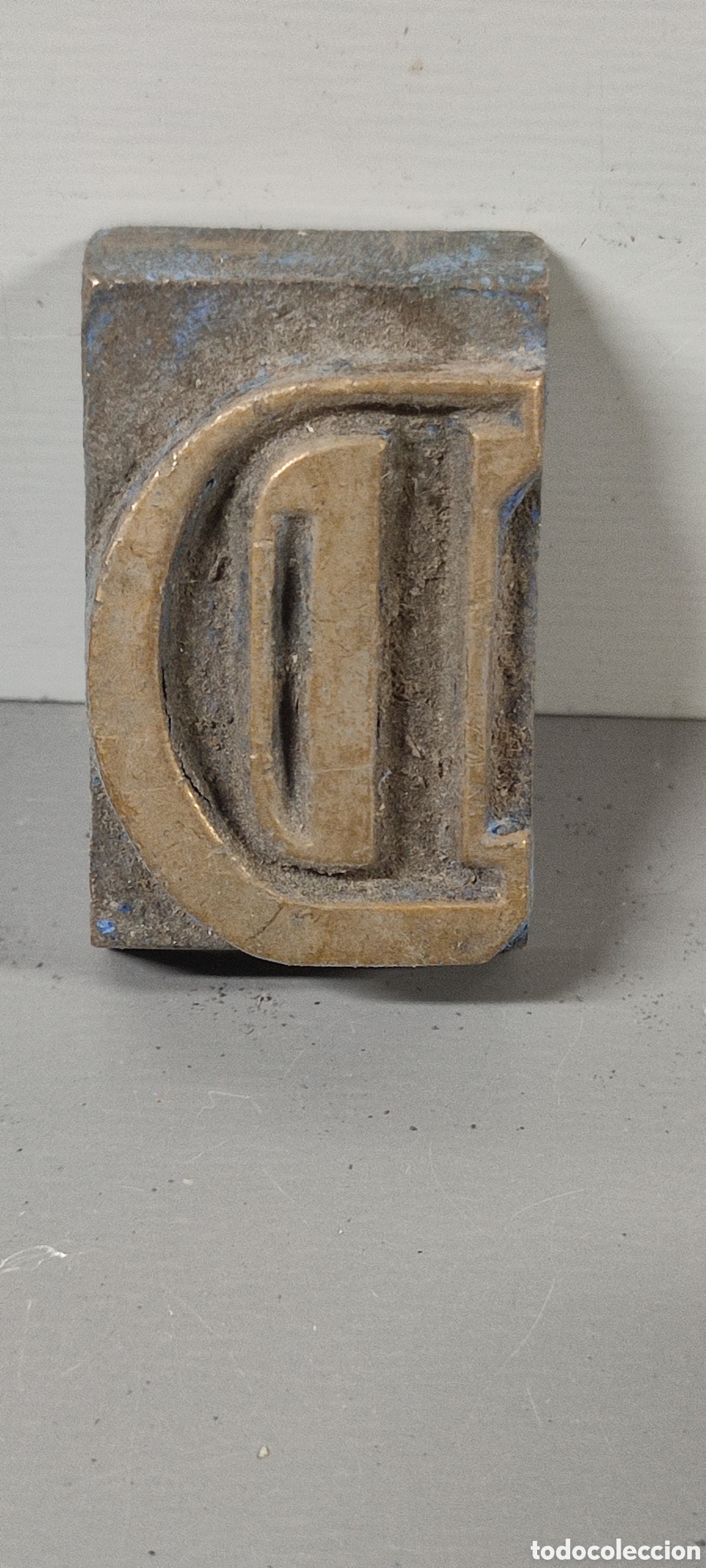 Antig&uuml;edades: Antigua letra tipogr&aacute;fica D de bronce. Mide aproximadamente 3 x 5 cm.
