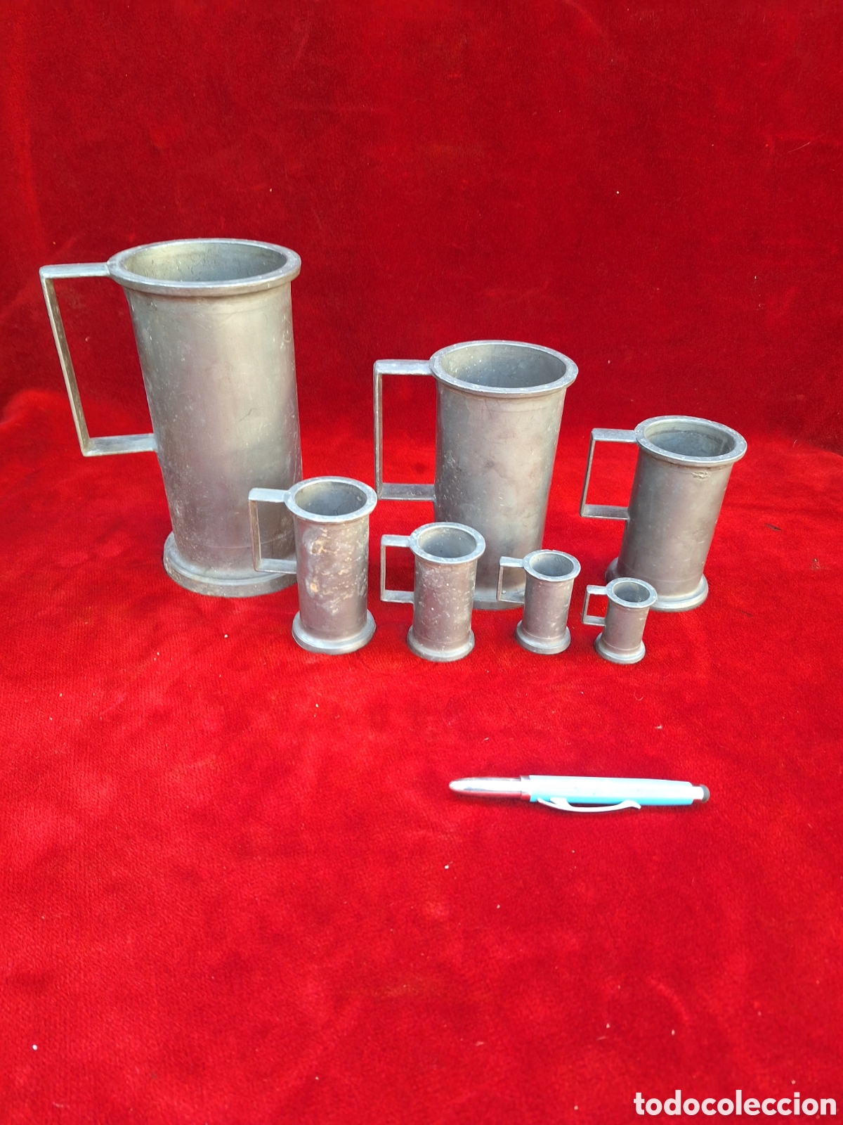 Antig&uuml;edades: Antiguo juego de 7 jarras medidoras,de esta&ntilde;o.Sello flor de lis!