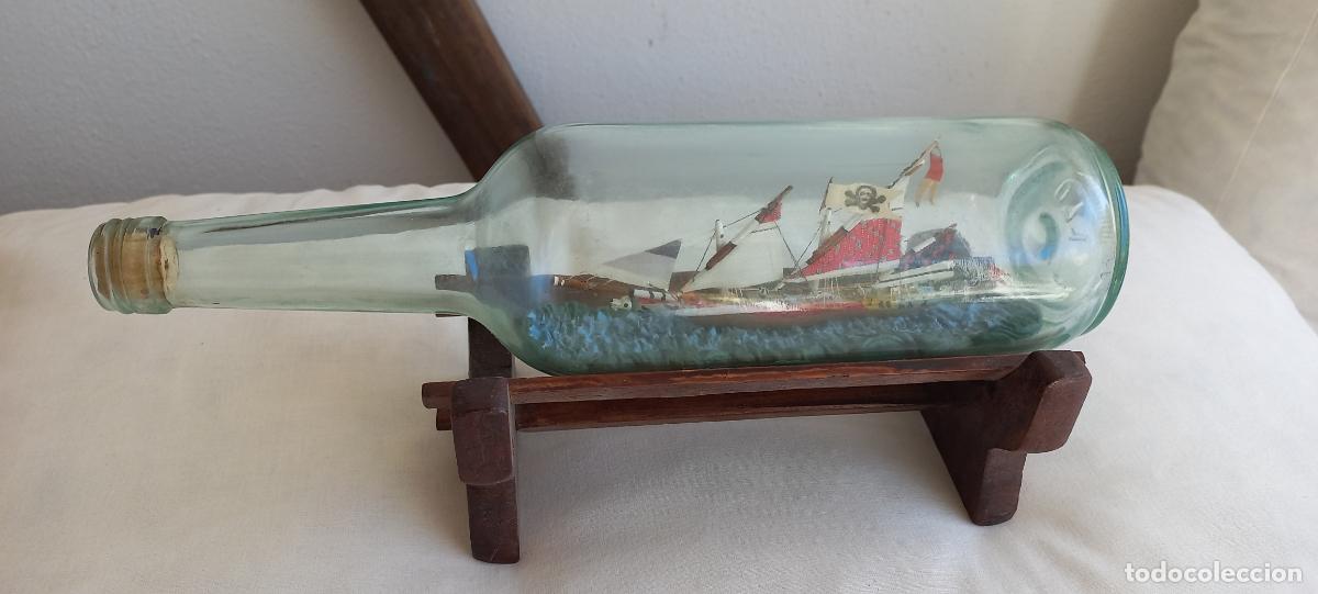 Antig&uuml;edades: Barco pirata velero, miniatura en botella de cristal con soporte de madera. Decoraci&oacute;n na&uacute;tica.
