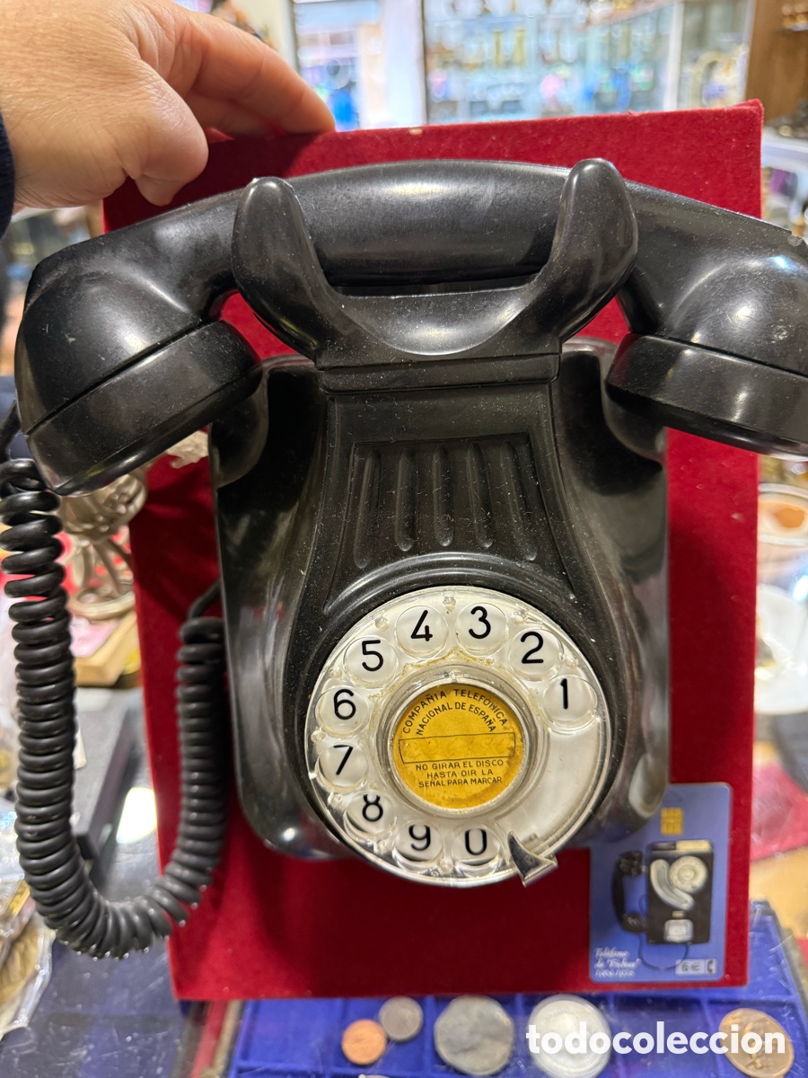 Tel&eacute;fonos: Antiguo tel&eacute;fono de baquelita negra, expuesto tabla de madera