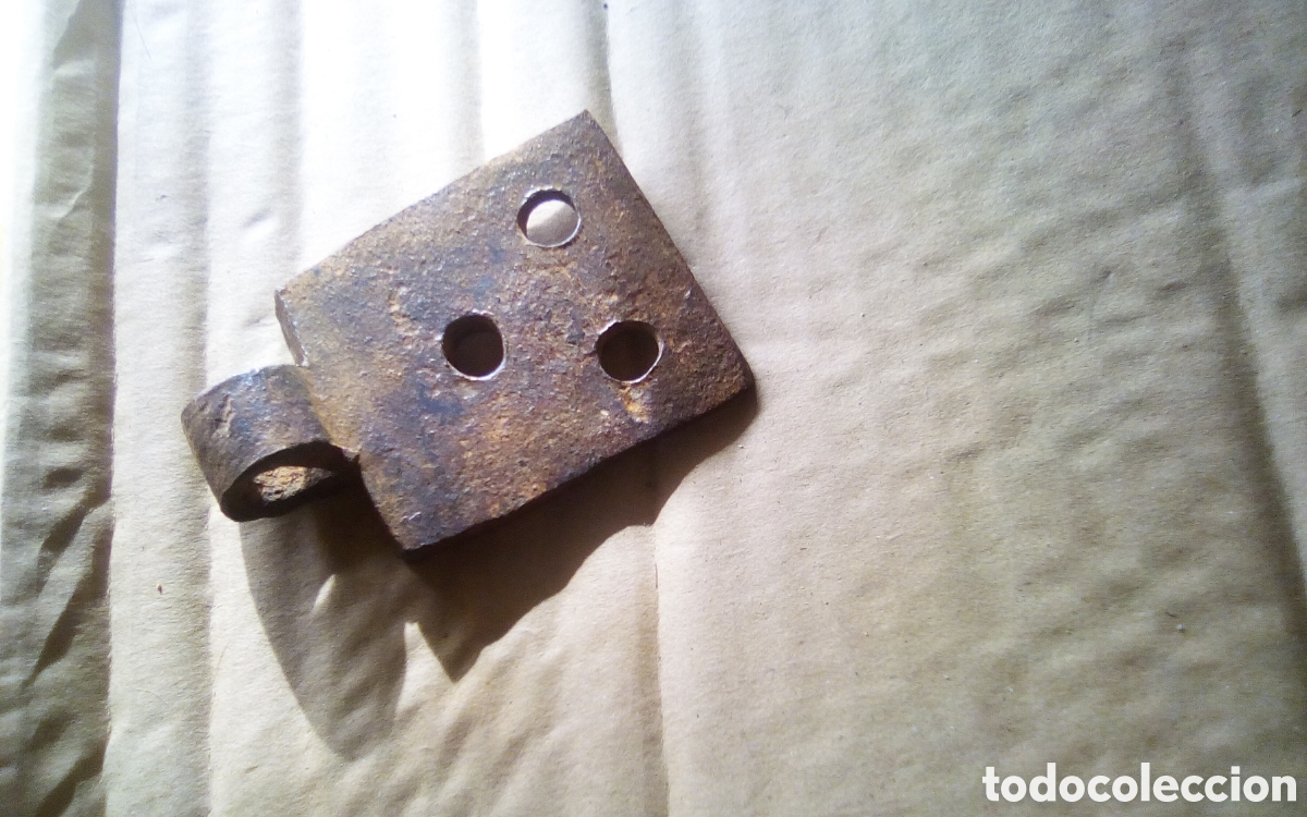 Antig&uuml;edades: Pieza bisagra antigua en hierro forjado. Mide 5,5 x 8 cm., el orificio 9 mm.