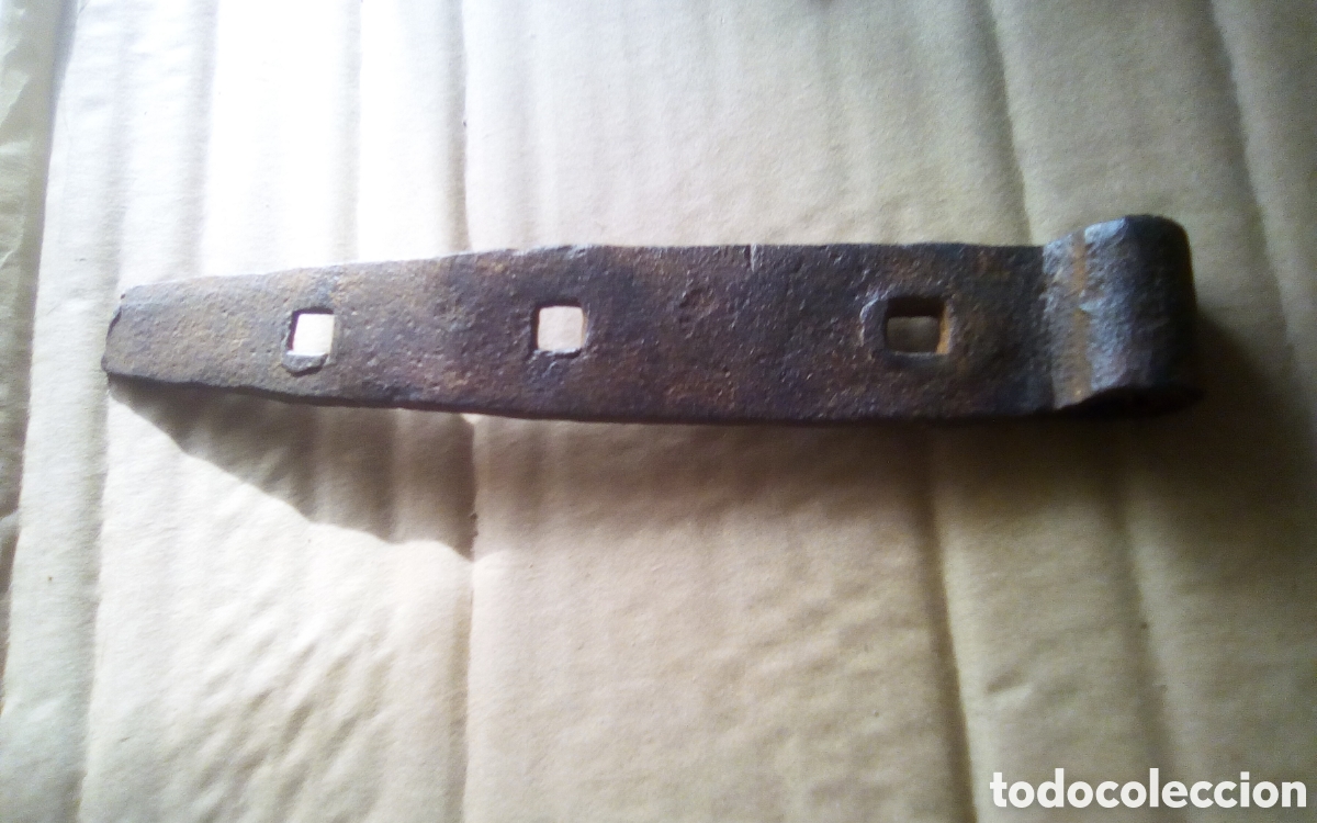 Antig&uuml;edades: Pieza bisagra antigua en hierro forjado. Mide 3,5 x 20 cm., el orificio 10 mm.