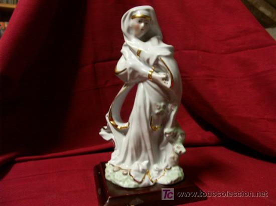 Antig&uuml;edades: Figura de porcelana con detalles dorados y sobre peana de madera