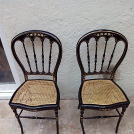 Dos sillas negras pintadas a mano antiguas.