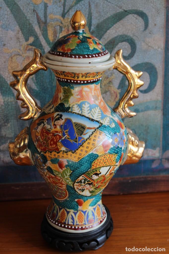 482-Grandes jarrones chinos en porcelana esmaltada con escenas palaciegas y  elementos vegetales con asas en dorado y boca ondulada. Sobre peana en mad