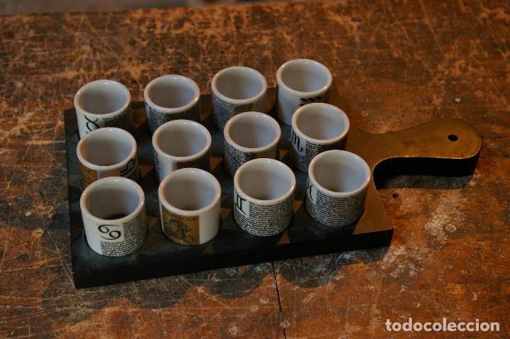 Antiguidades: tazas con signos horoscopo sobre una tablilla