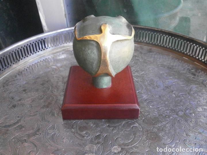 Antiquit&auml;ten: Bola bronce bicolor indalo sobre peana de madera altura total 10 cm. peana 8,5 X 8,5 cm.