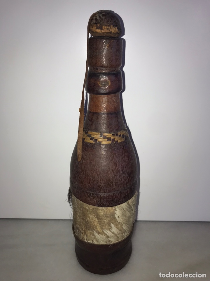 Antig&uuml;edades: Botella de cristal forrada de piel