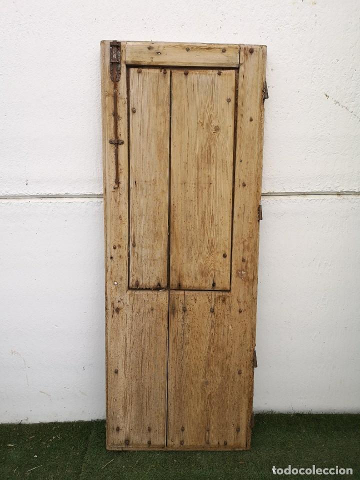 Puerta de clavos con postigo