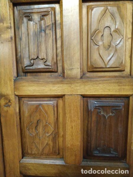 Antiguidades: Armario de madera de dos puertas con cuarterones adornados con pergaminos y cuadrifolias alternados.
