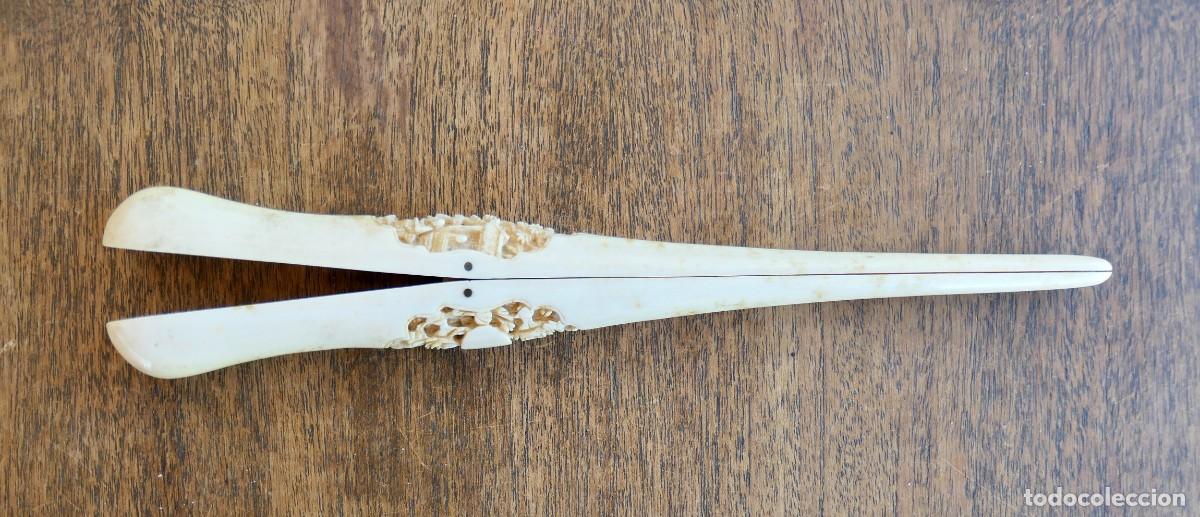 Antig&uuml;edades: Abridor de dedos guante de hueso, tallas con motivo de figuras orientales y vegetaci&oacute;n. 23,5 CM