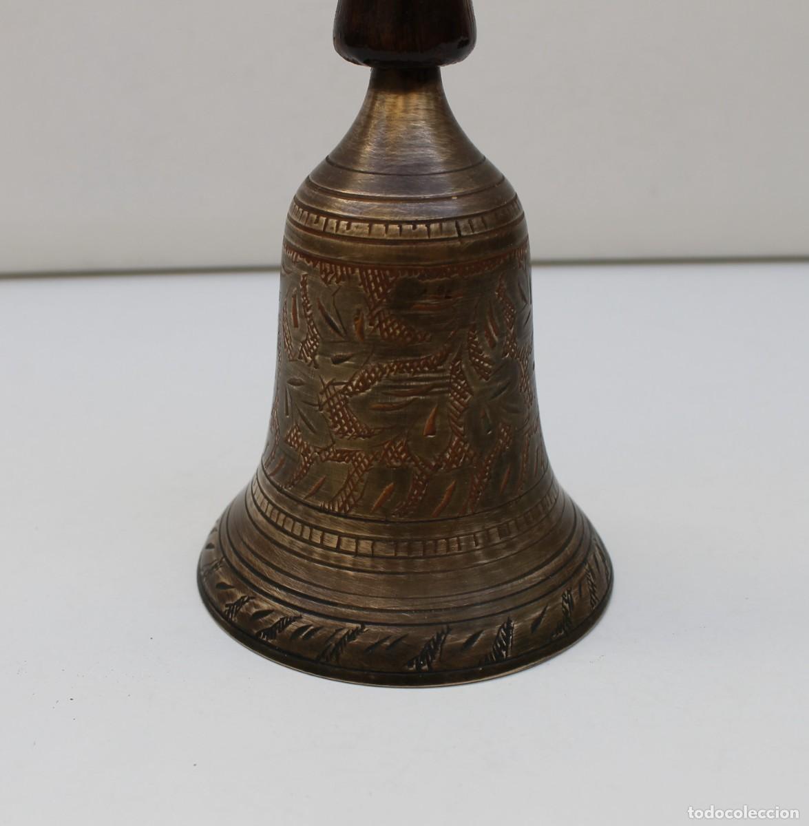 Antiguidades: CAMPANA LLAMADOR DE BRONCE Y MANGO DE MADERA CON GRABADOS.