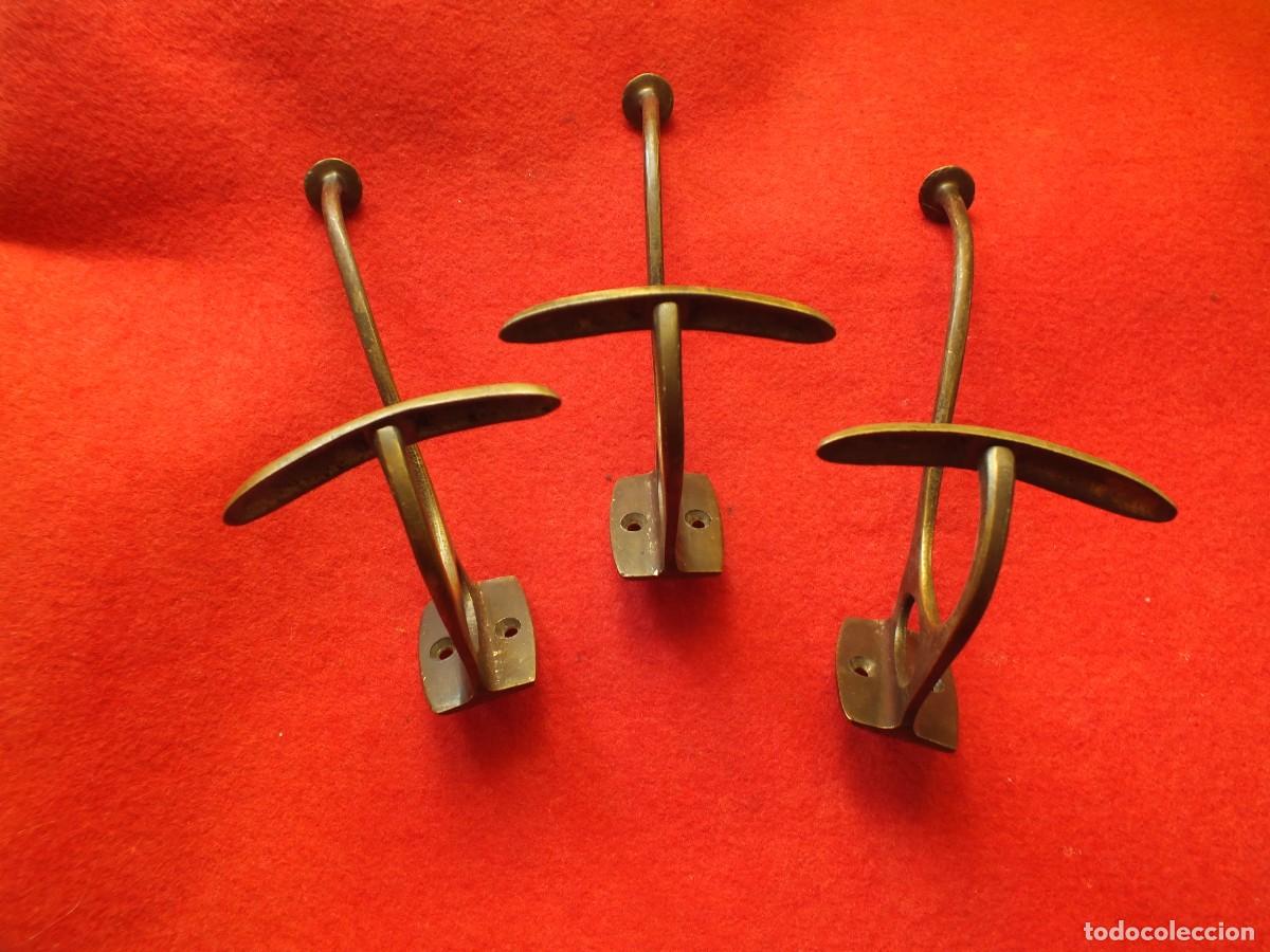 Antiguidades: Tres antiguas perchas en bronce con doble colgador, para pared