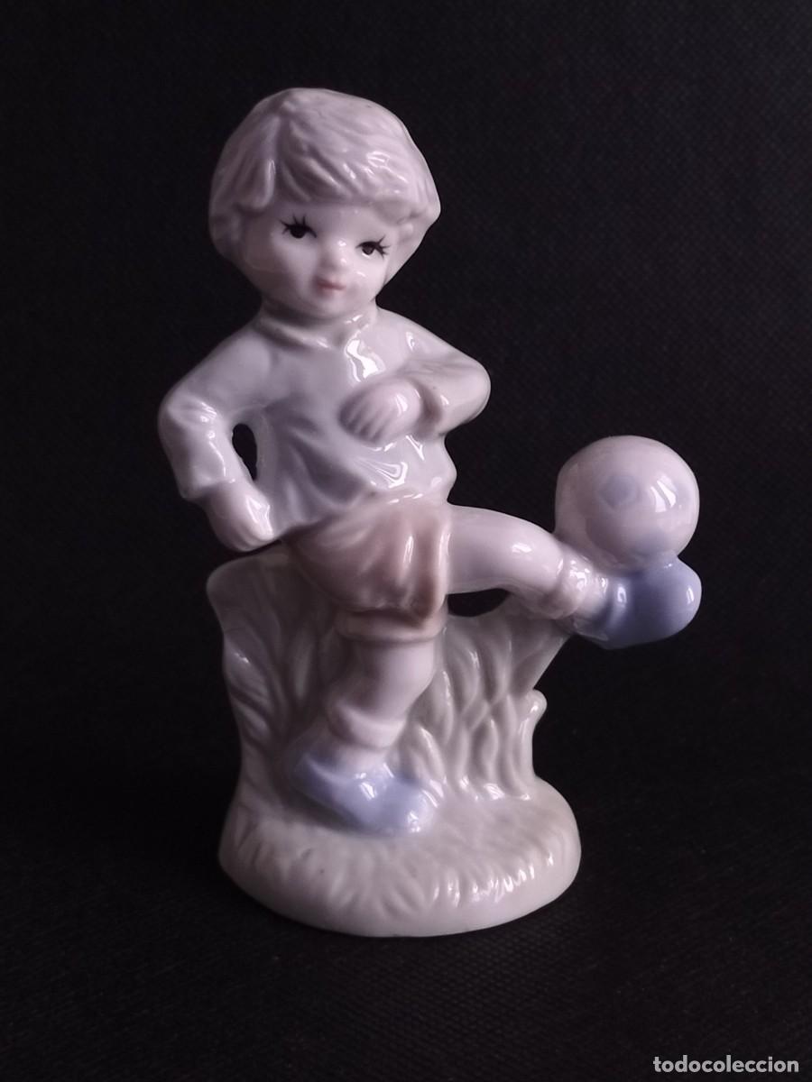 Antig&uuml;edades: FIGURA DE NI&Ntilde;O PRACTICANDO FUTBOL. PORCELANA.