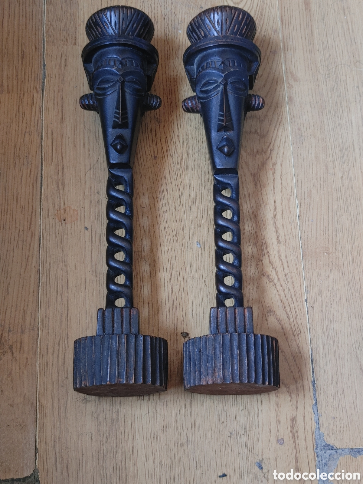 Antig&uuml;edades: Pareja de candeleros en madera tallada y calada. Con motivo africano.