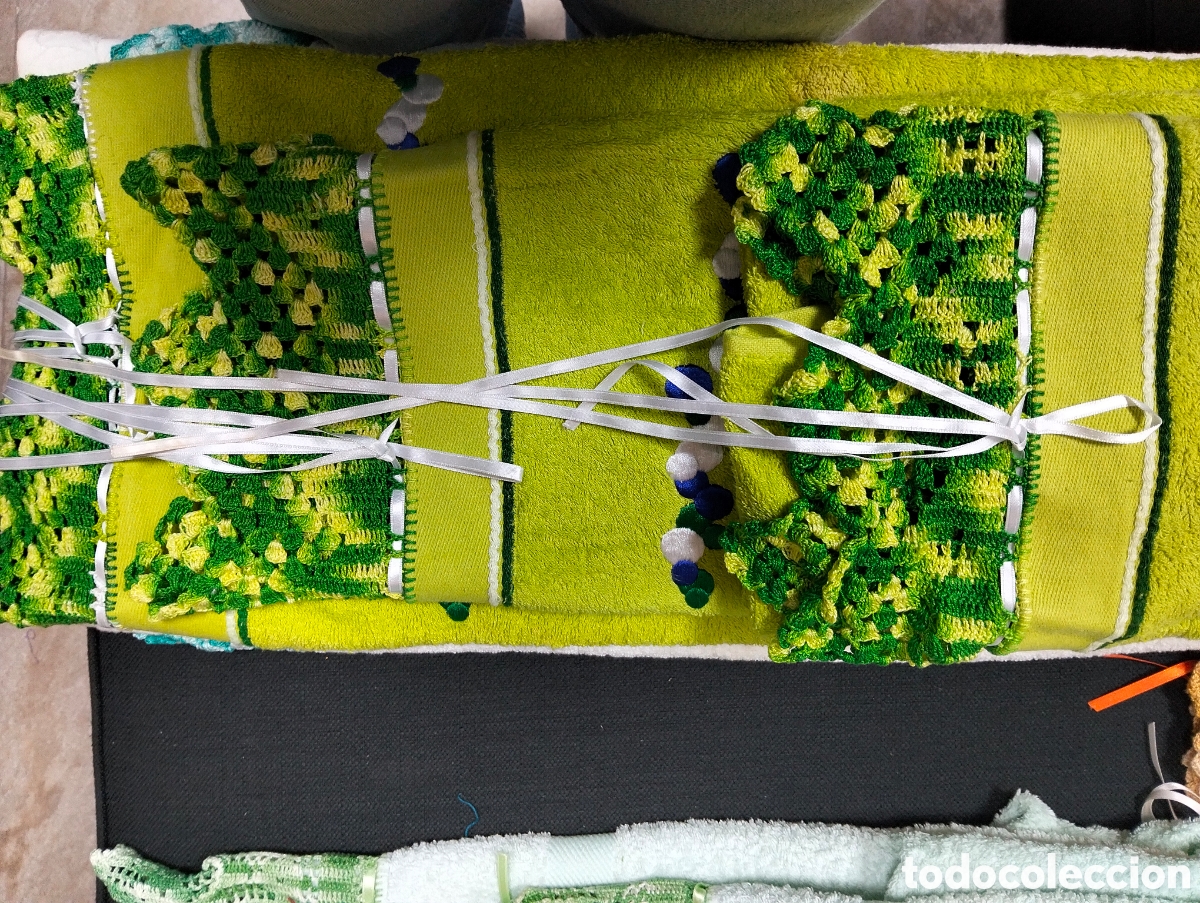Antig&uuml;edades: toallas artesanales decoradas con bordes de crochet en tonos verdes y cintas blancas.