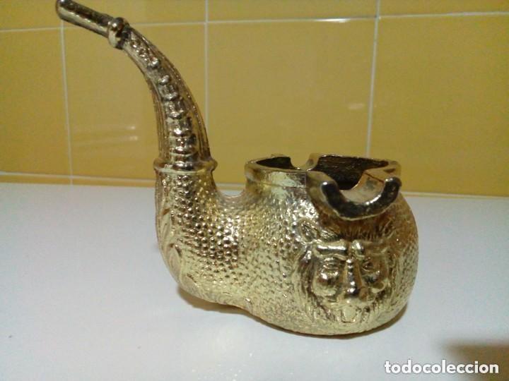 Antig&uuml;edades: cenicero de bronce en forma de pipa y cabeza tallada de leon