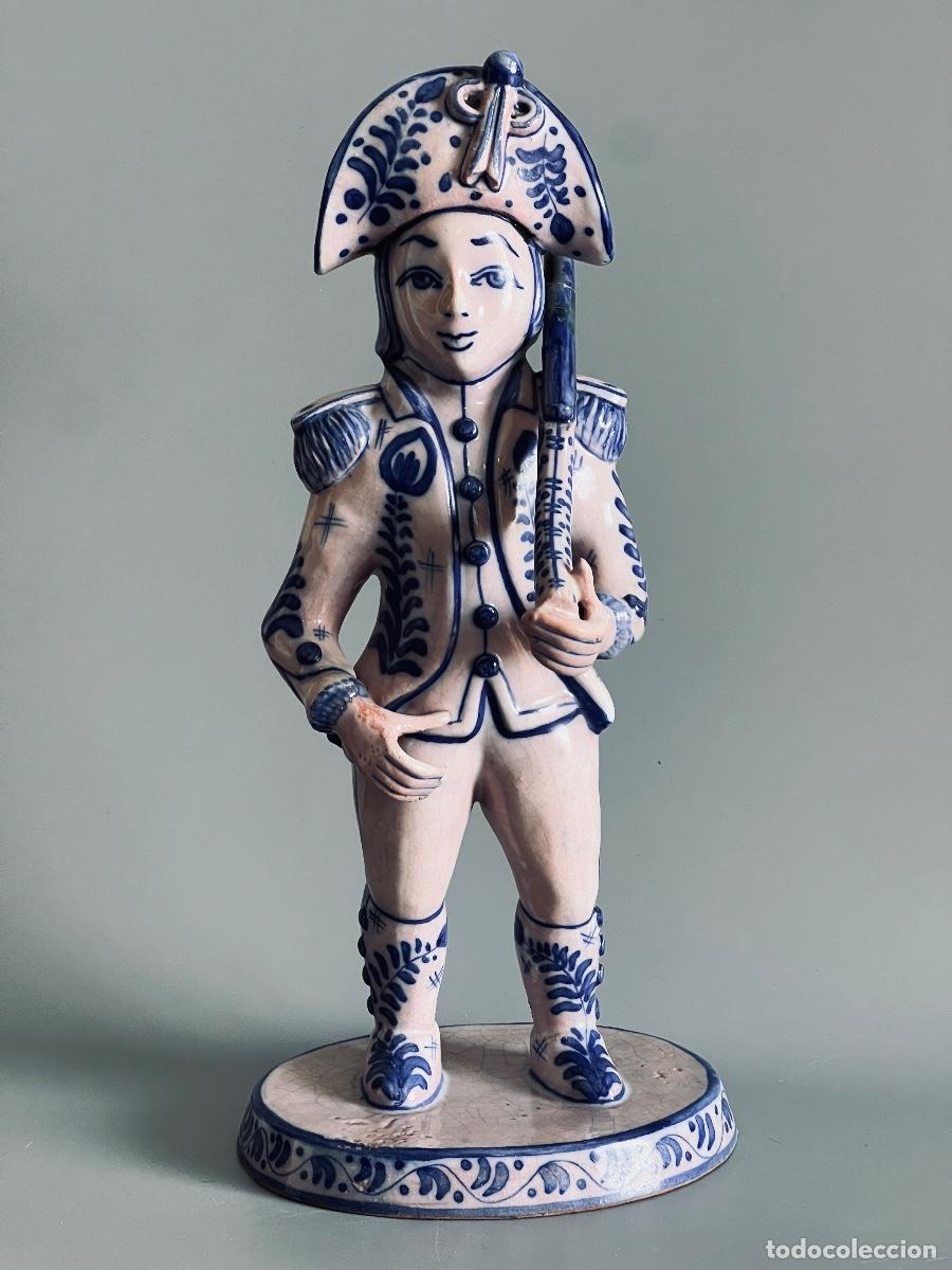 Antig&uuml;edades: Soldado de cer&aacute;mica en esmalte azul y craquelado blanco. 32 cm de altura.