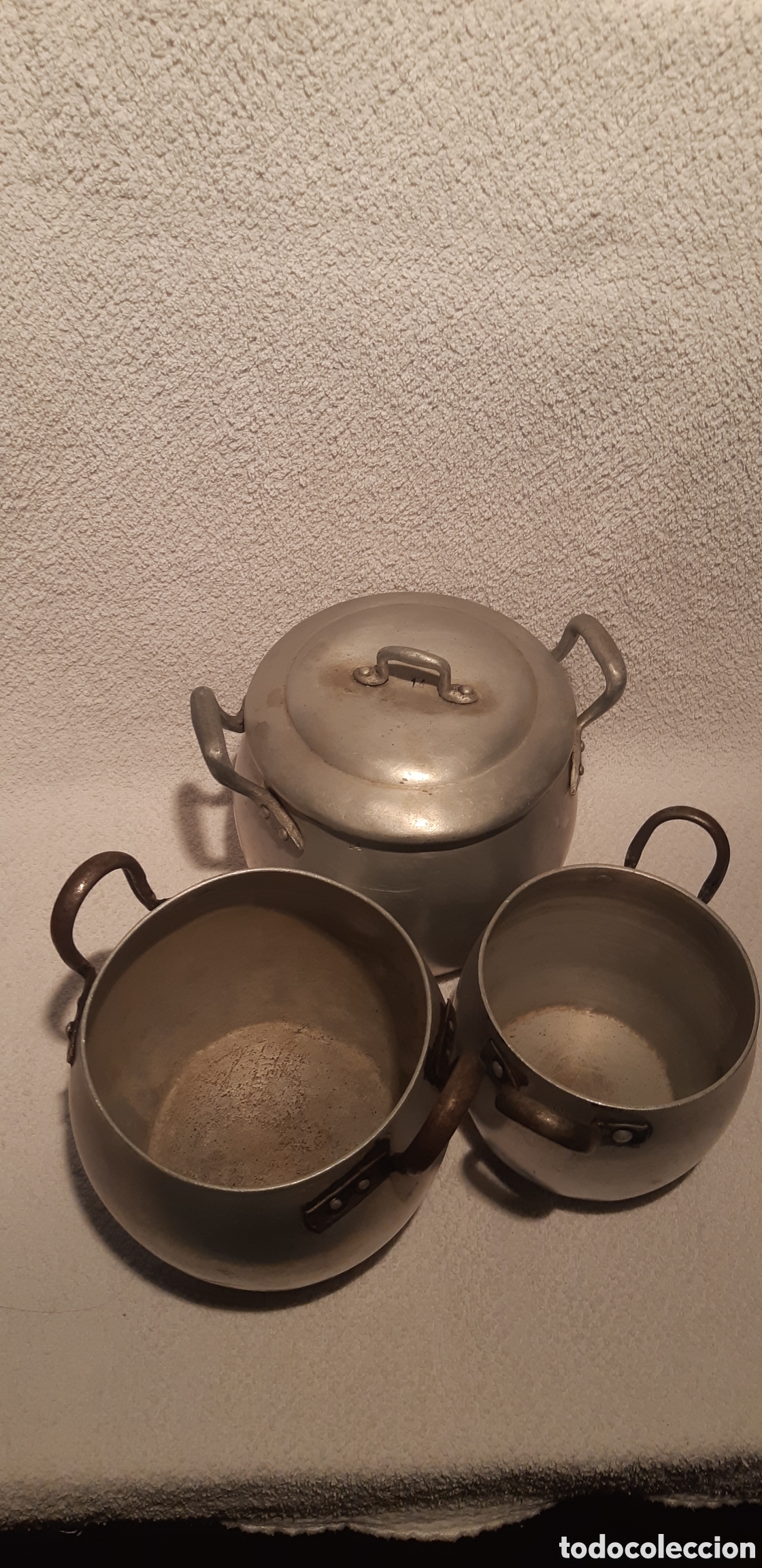 Antig&uuml;edades: Tres cazuelas de aluminio antiguas de distintos tama&ntilde;os. La mayor con tapadera