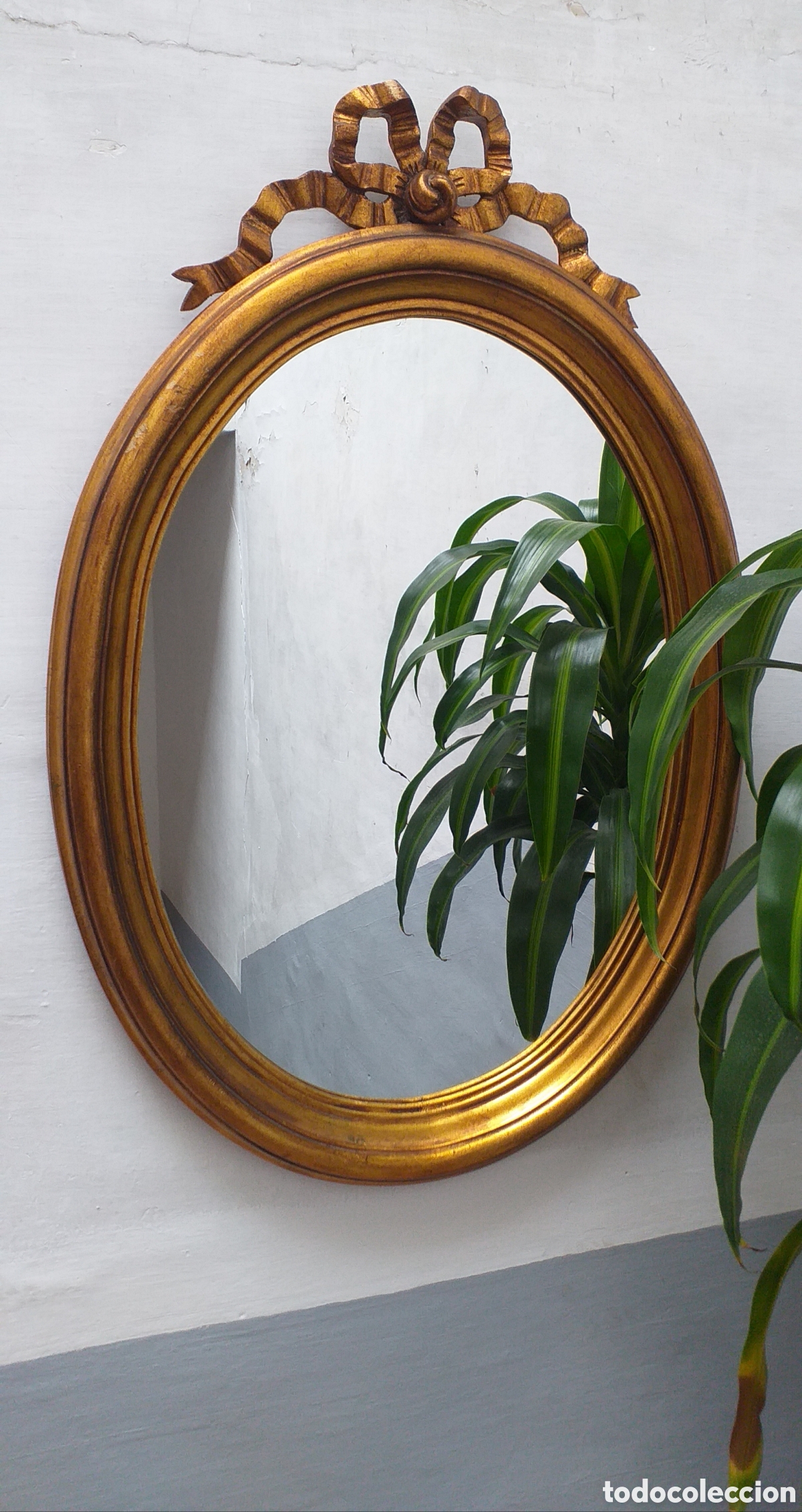 Antig&uuml;edades: Espejo ovalado dorado con adorno