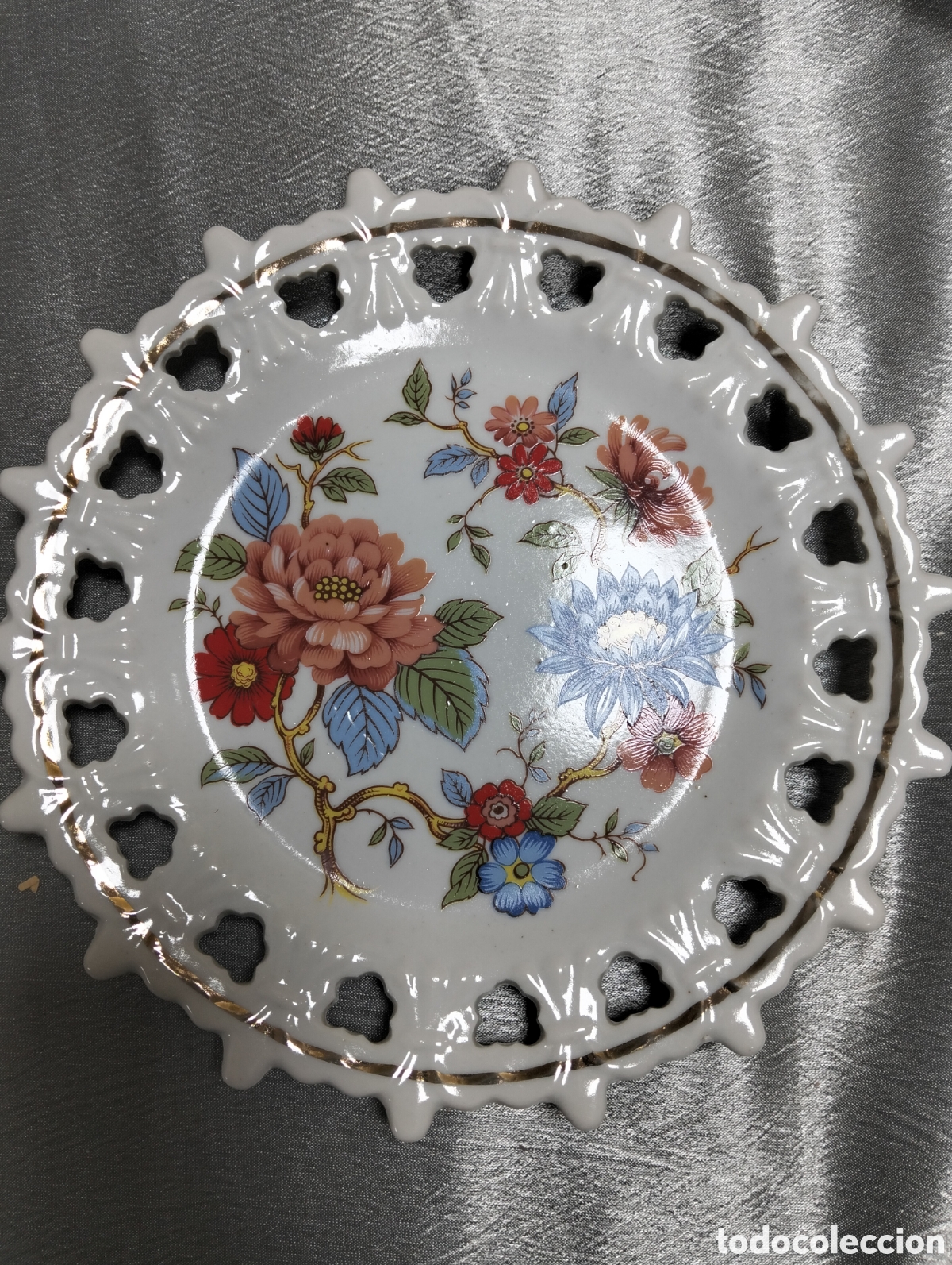 Antig&uuml;edades: plato decorativo de porcelana con un dise&ntilde;o floral de estilo vintage y bordes calados o reticulados.
