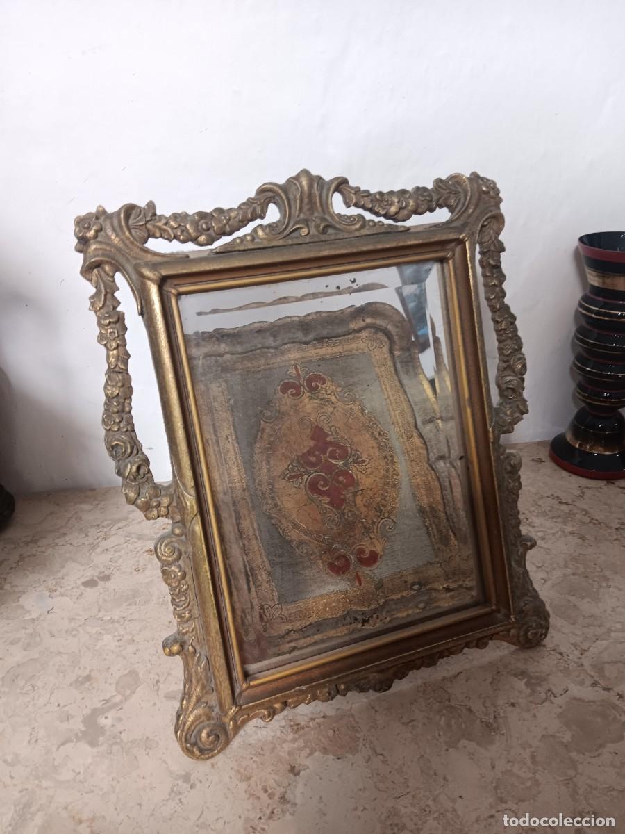 Antig&uuml;edades: espejo de estilo barroco con un marco dorado tallado y detalles ornamentados