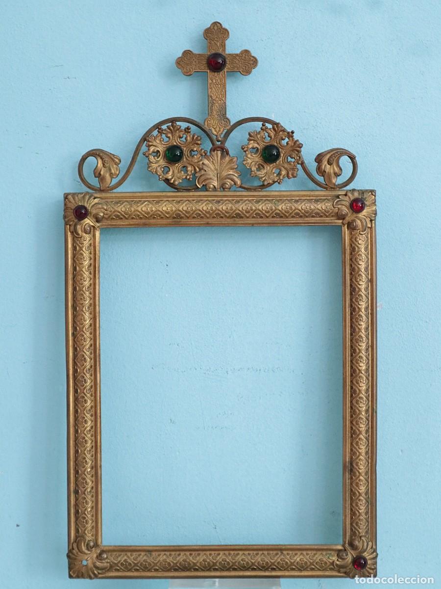 Antig&uuml;edades: Marco elaborado en bronce y lat&oacute;n repujado y dorado. Siglo XIX. Mide 41 x 23 cm.