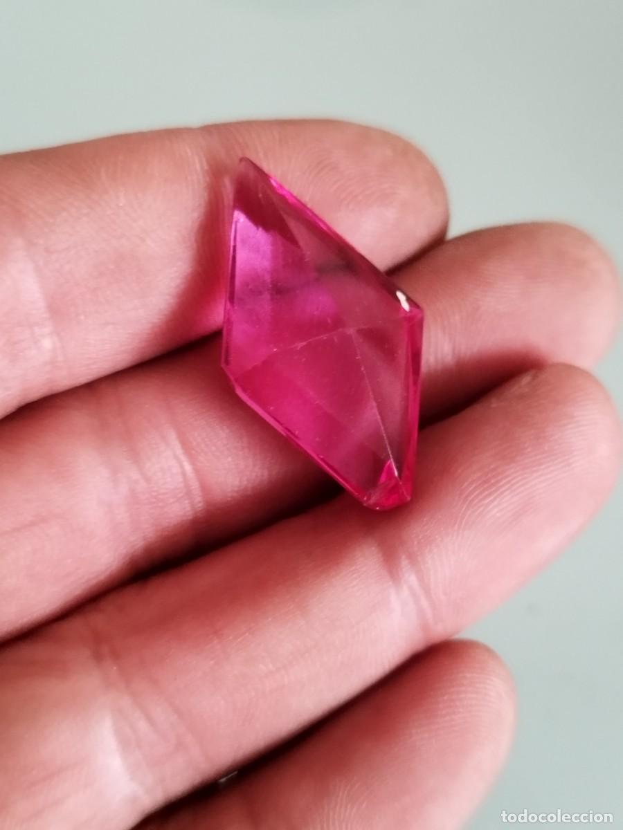 Antig&uuml;edades: Antiguo cristal tallado de color rosado en forma de gema. Con falta.
