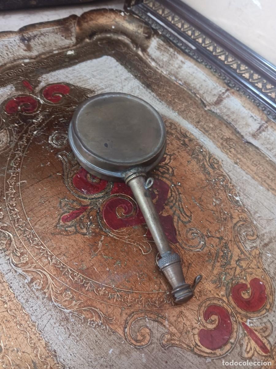 Antig&uuml;edades: aceitera de lat&oacute;n antigua, com&uacute;nmente utilizada para maquinaria o armas.Uso Militar: Se han identifi
