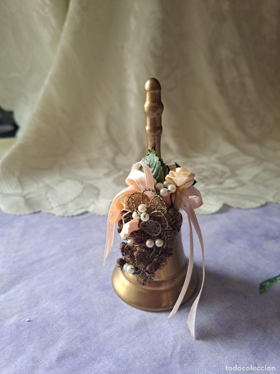 Antig&uuml;edades: Bonita campana de bronce con corona de flores.