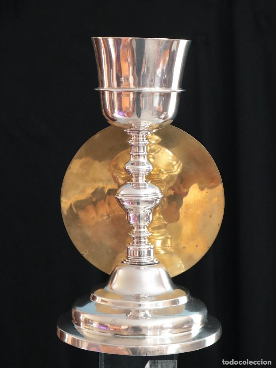 Antig&uuml;edades: C&aacute;liz lit&uacute;rgico elaborado en plata acompa&ntilde;ado de patena. Siglos XVIII-XIX. Mide 24 cm de altura.
