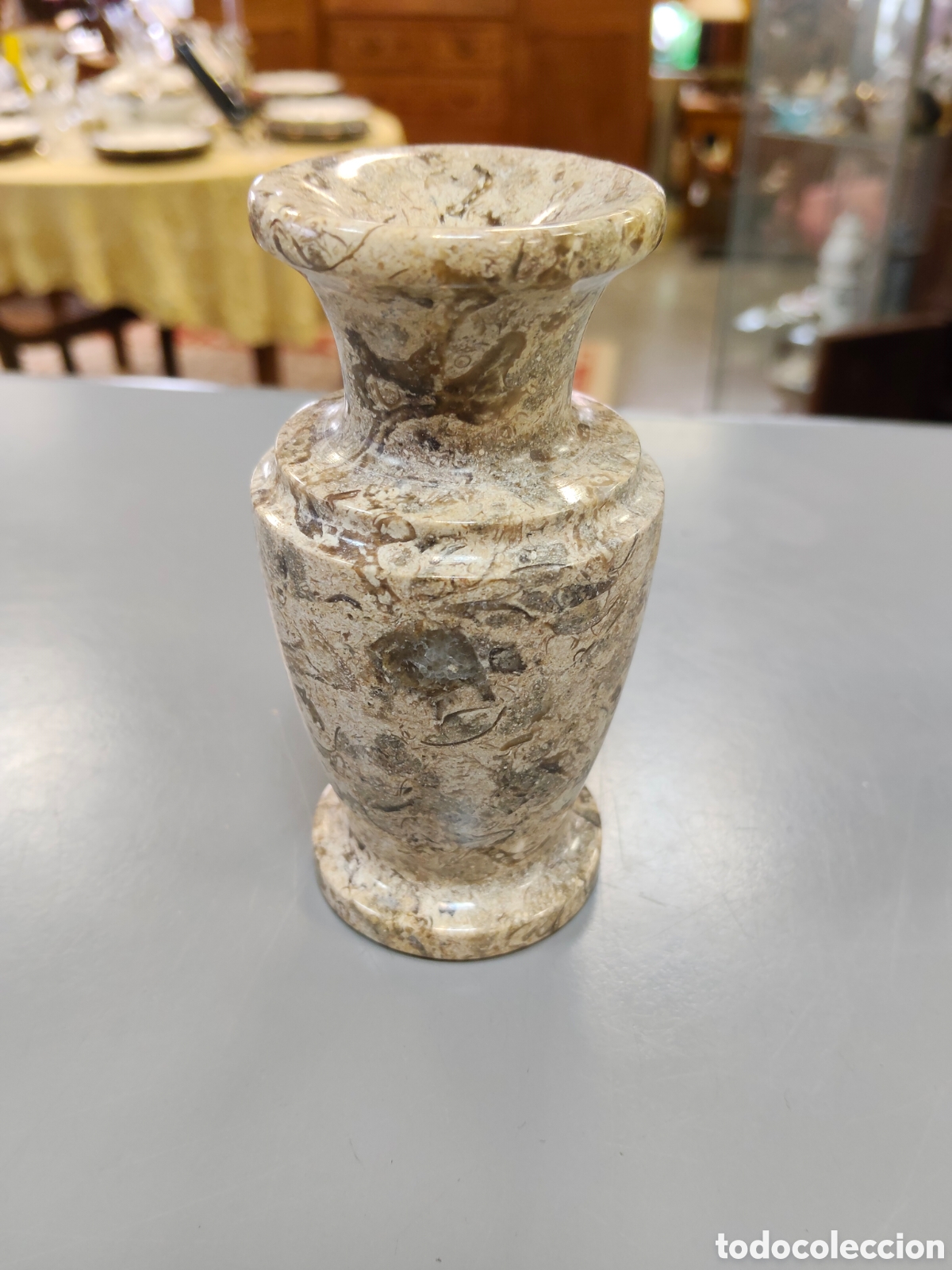 Antig&uuml;edades: jarr&oacute;n de mesa decorativo hecho de piedra f&oacute;sil tallada a mano con un patr&oacute;n moteado marr&oacute;n y beige.