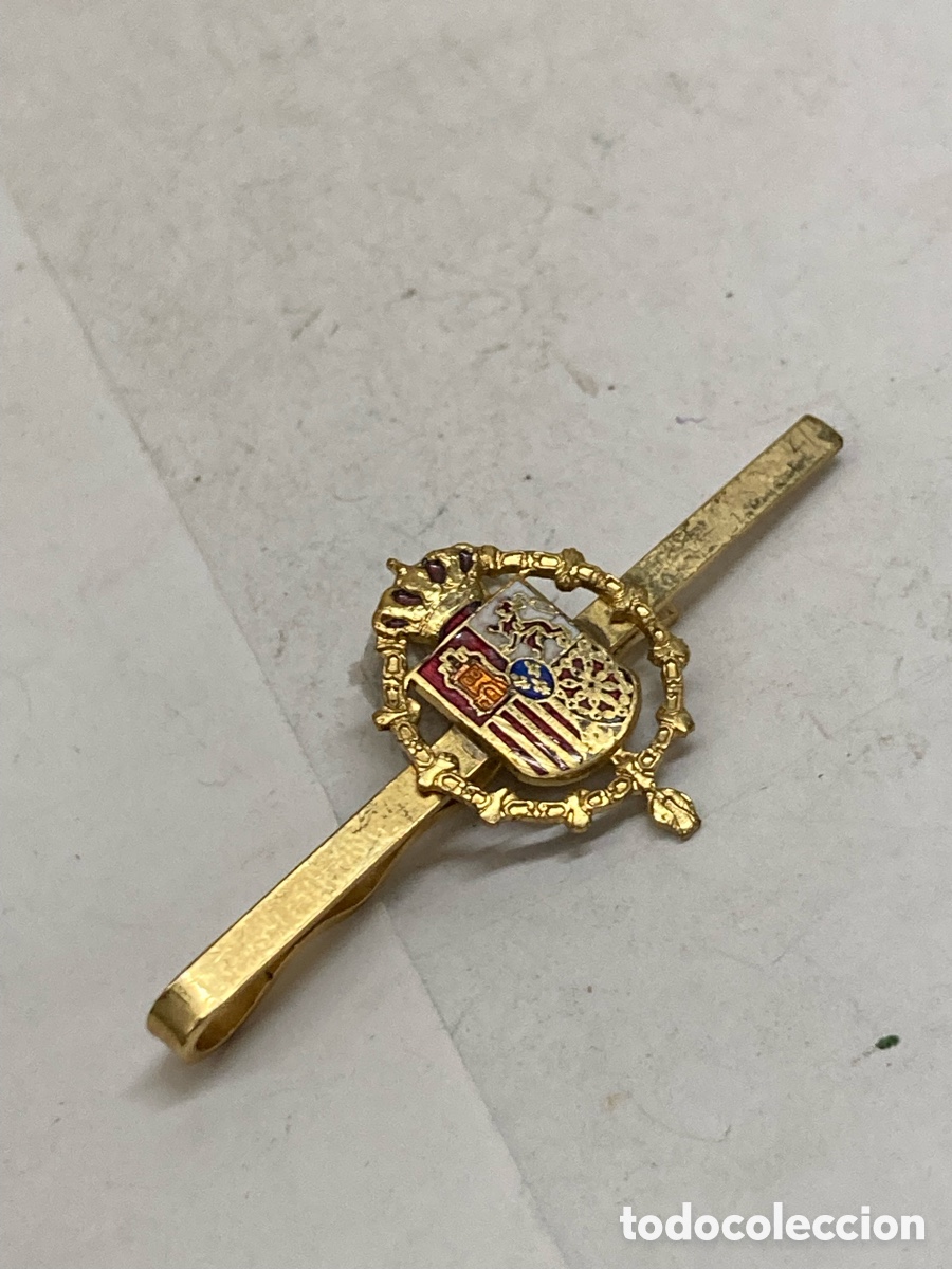 Antig&uuml;edades: pisacorbatas dorado con el escudo de armas de la Casa Real de Espa&ntilde;a