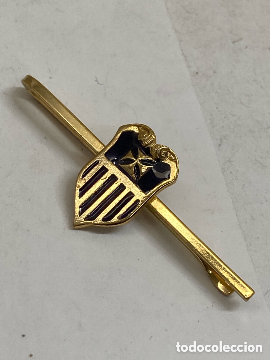 Antig&uuml;edades: pasador de corbata dorado con un escudo esmaltado en azul y rojo