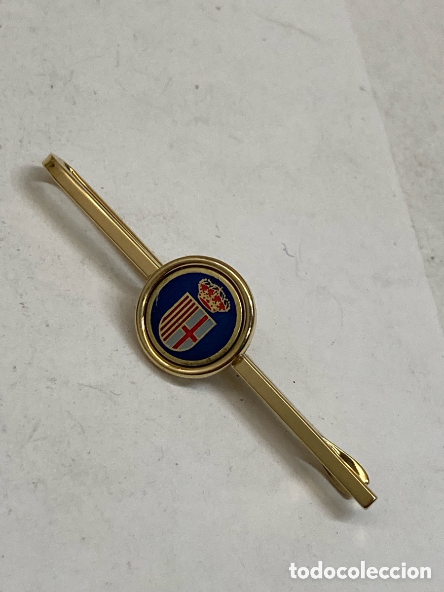 Antig&uuml;edades: pasacorbatas presenta un dise&ntilde;o circular con un escudo her&aacute;ldico