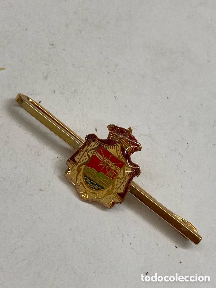 Antig&uuml;edades: pisacorbatas de lat&oacute;n esmaltado con el escudo de Espa&ntilde;a.
