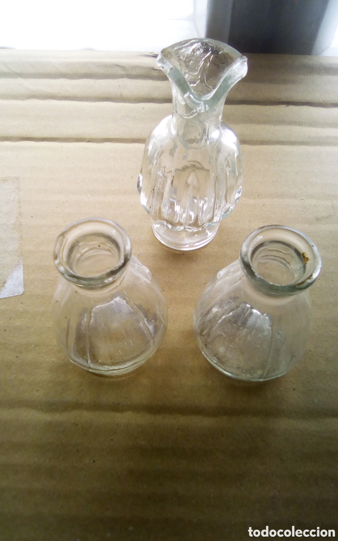 Antig&uuml;edades: Tres botellitas de licor en cristal. La grande mide 9 cm., boca con peque&ntilde;a rotura.