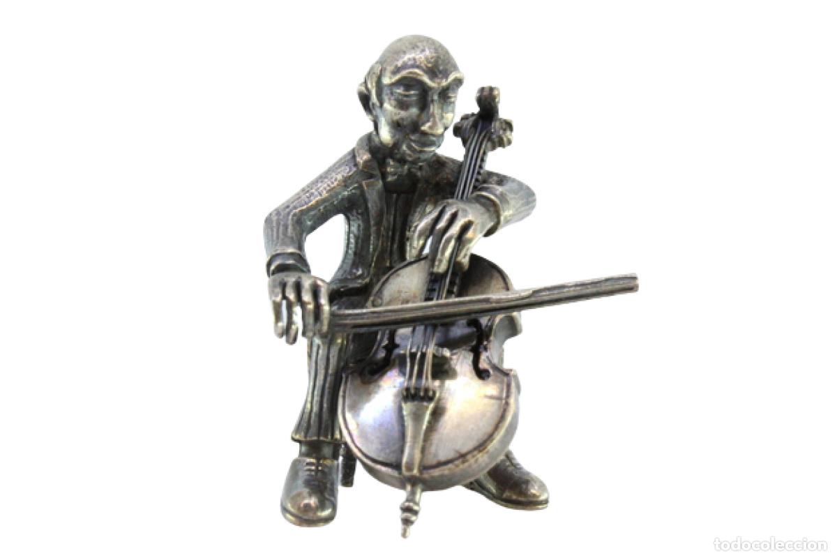 Antig&uuml;edades: M&uacute;sico vestido de plata tocando el violonchelo