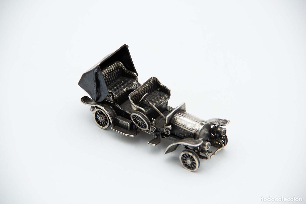Antiguidades: Coche descapotable del siglo XIX, de color plata.