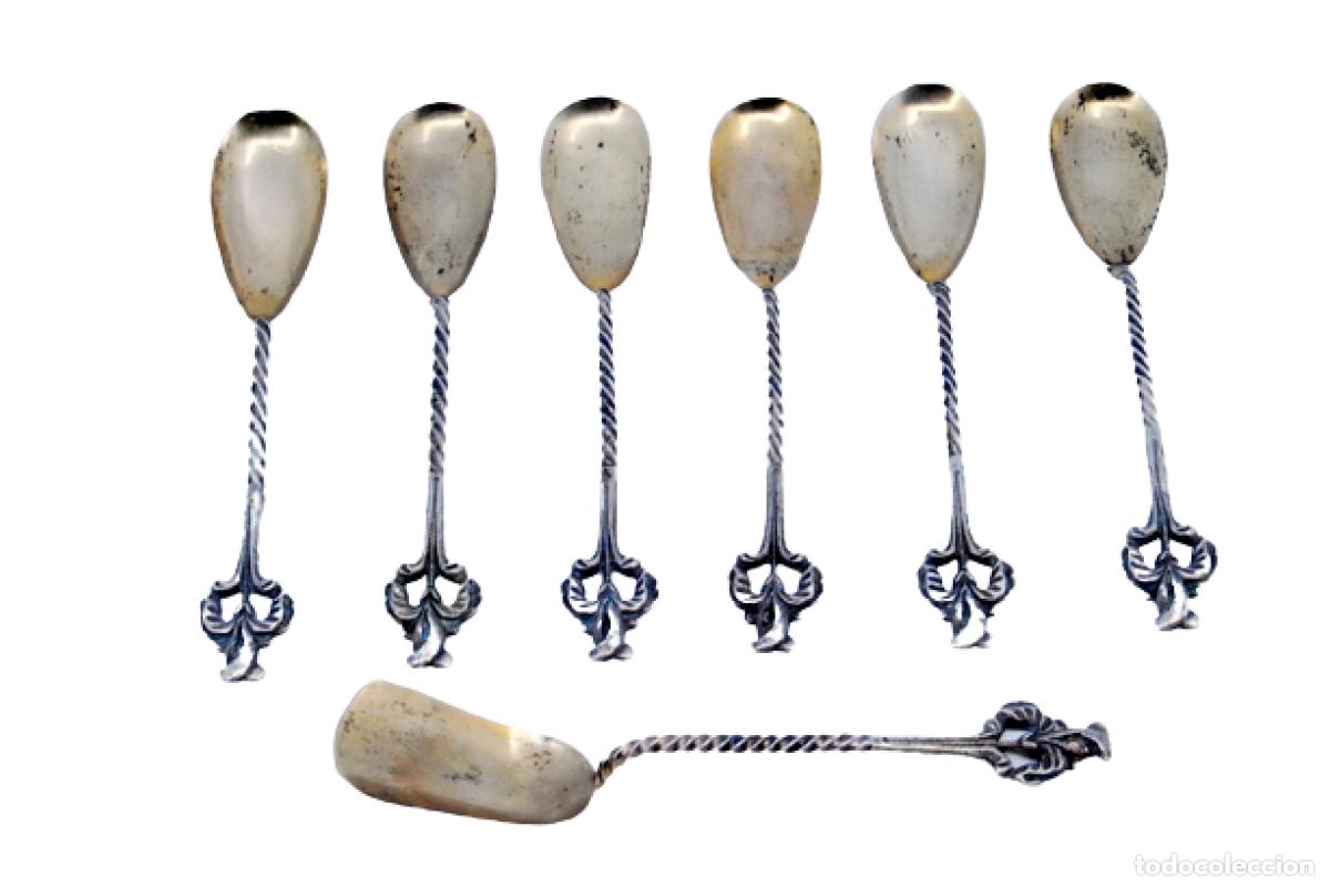Antig&uuml;edades: Juego de 6 cucharas de az&uacute;car y una cuchara medidora, en color plata.