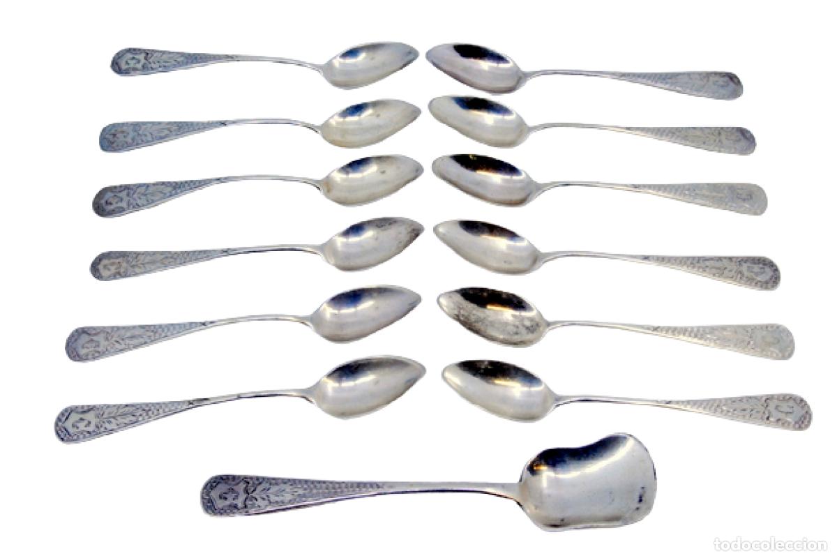 Antiguidades: Juego de 12 cucharas de az&uacute;car y una cuchara medidora, en color plata.