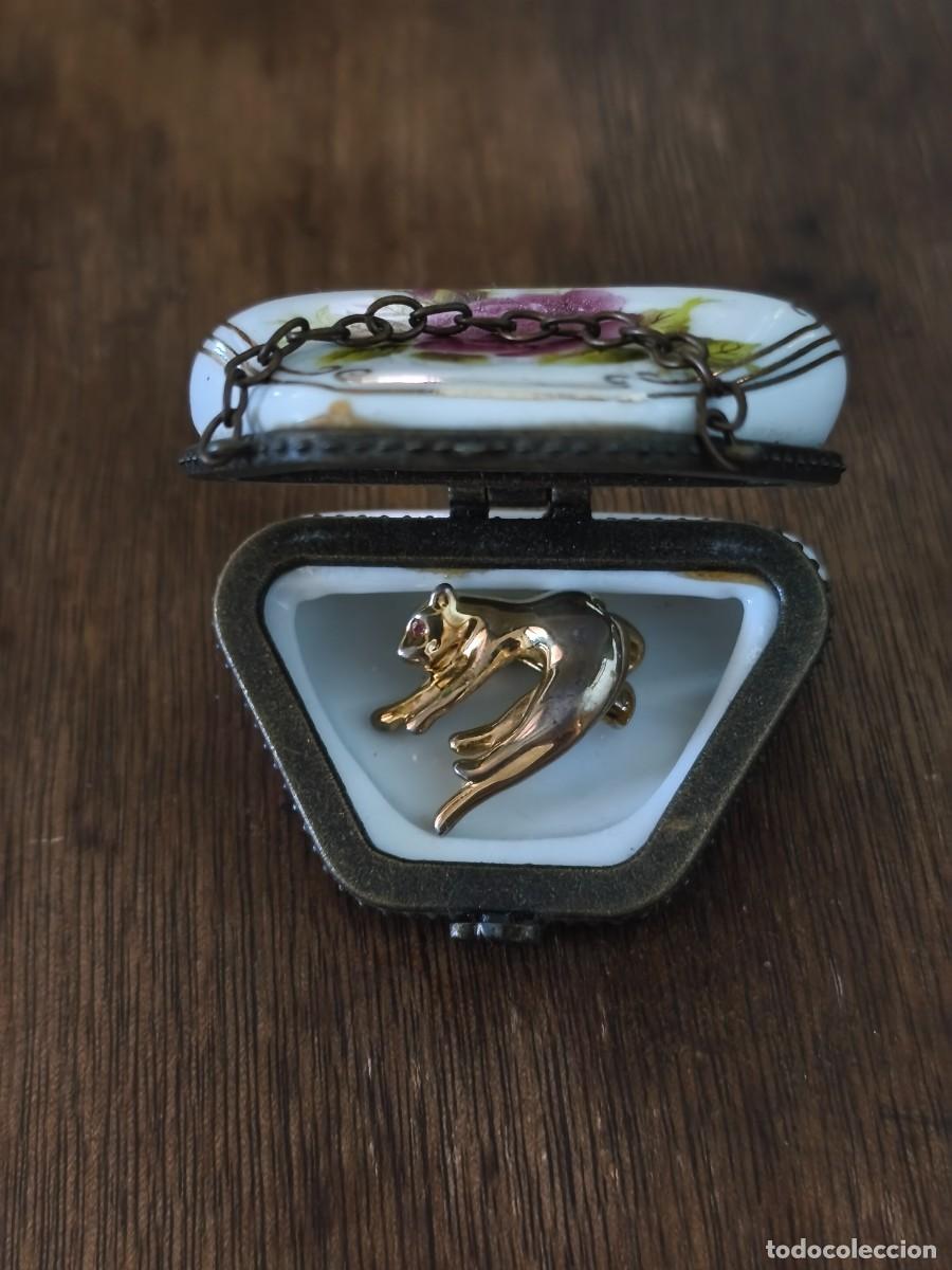 Antiquit&auml;ten: Cajita bolsito de porcelana que guarda broche-colgante de pantera dorada.