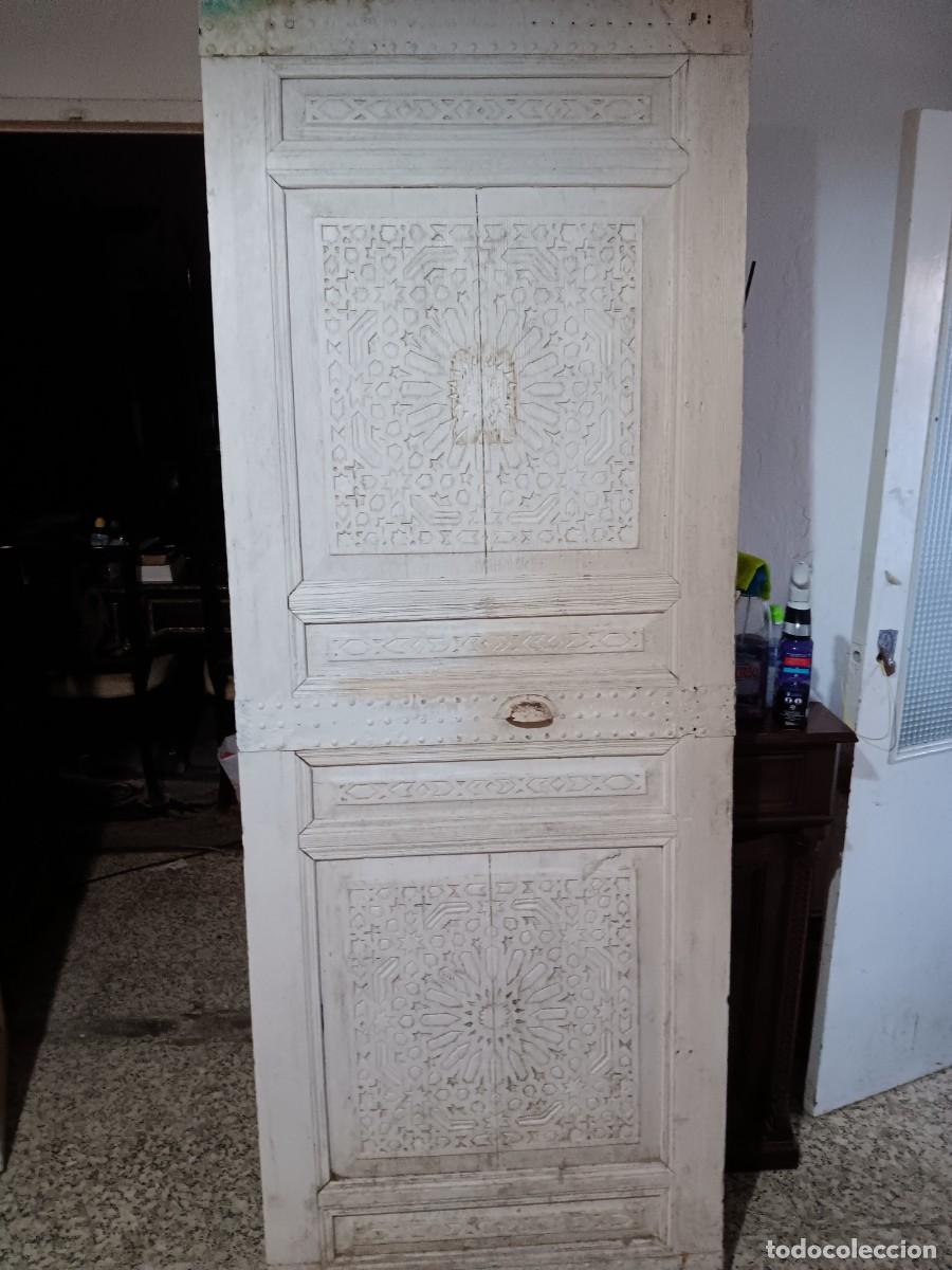 Antig&uuml;edades: Puerta de madera antigua con intrincados tallados geom&eacute;tricos y un acabado blanco desgastado.Estilo: