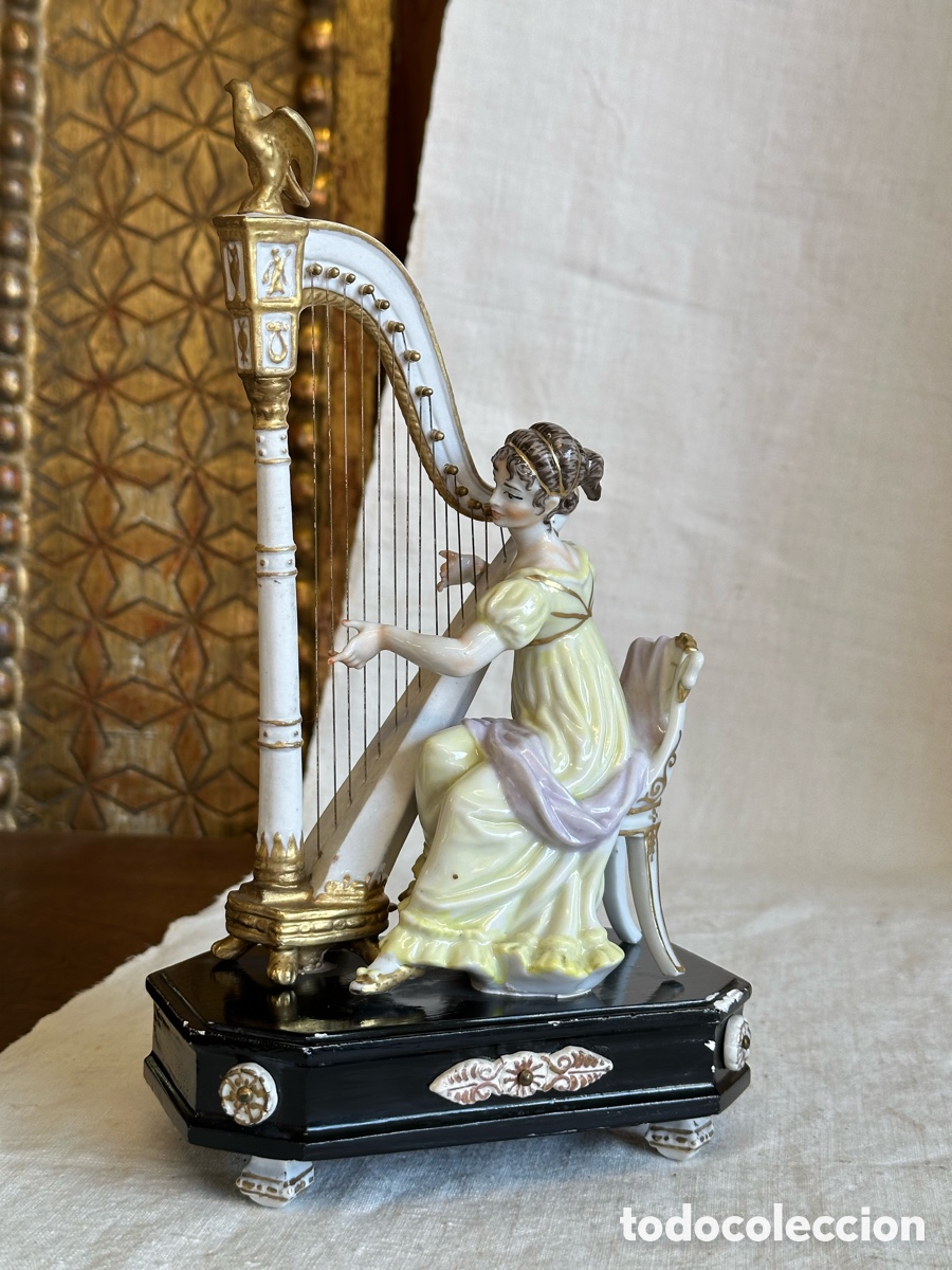 Antig&uuml;edades: Dama dieciochesca tocando el arpa. Seg&uacute;n modelo cl&aacute;sico europeo. Porcelana vidriada y biscuit. Peana