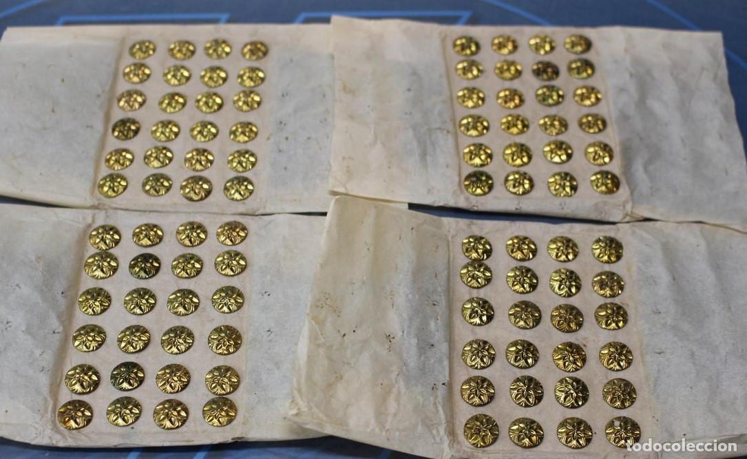 Antig&uuml;edades: Antiguos botones met&aacute;licos dorados con flor en relieve.