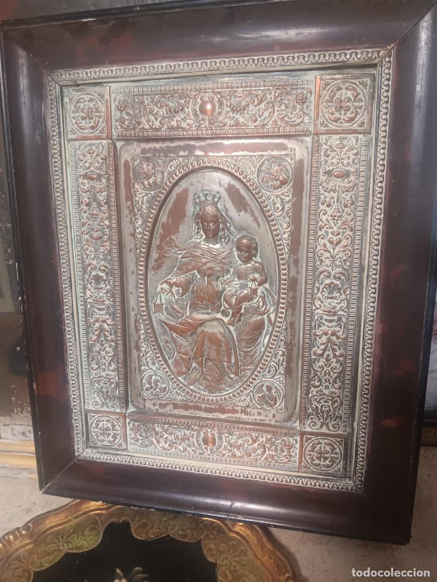 Antig&uuml;edades: cuadro religioso es un relieve met&aacute;lico de cobre repujado que representa a la Virgen del Carmen con