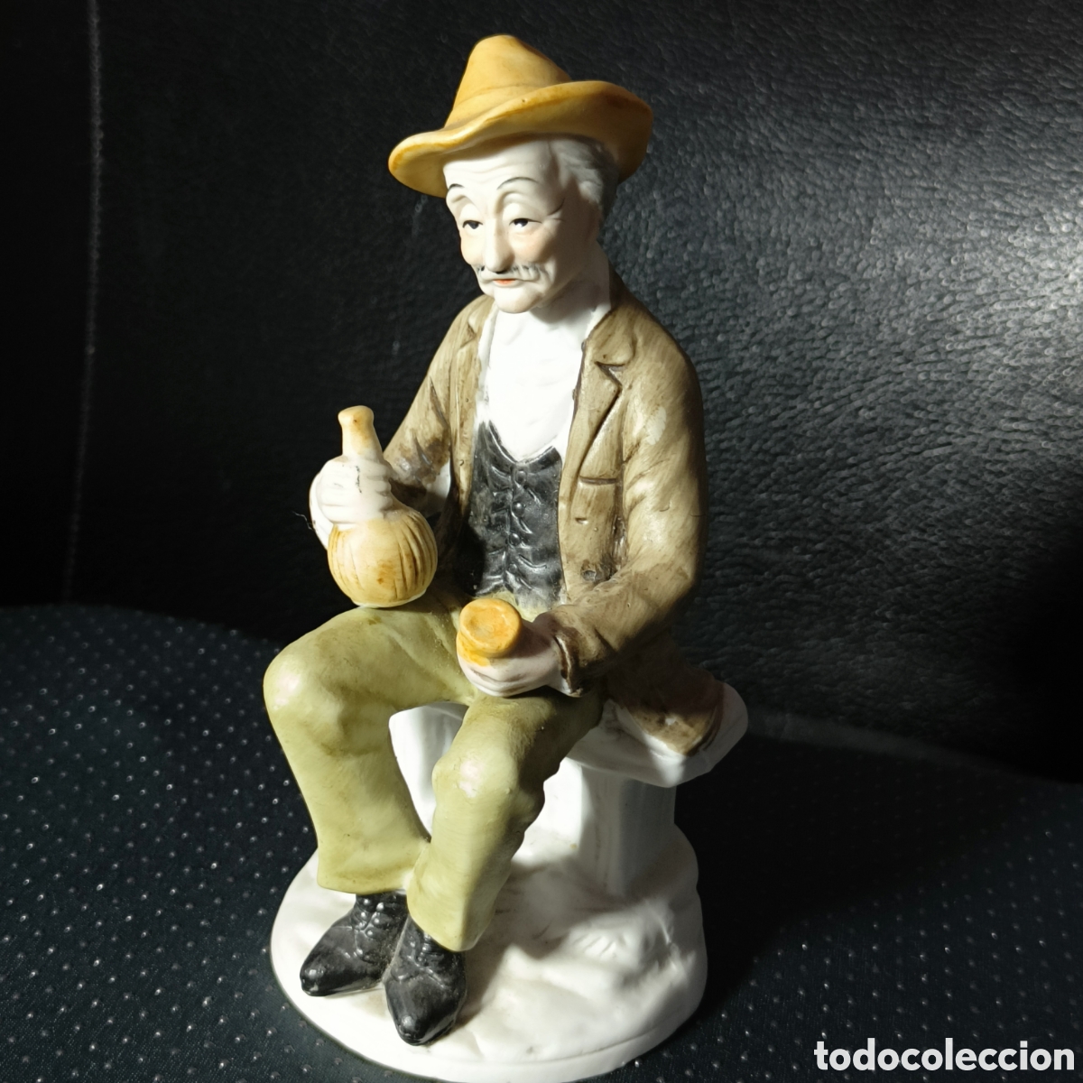 Antiquit&auml;ten: Figura de porcelana antigua, hombre anciano sentado con bota de vino. Estilo costumbrista