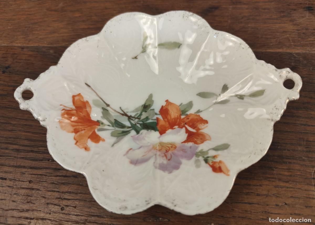 Antig&uuml;edades: Bonito plato de porcelana con forma lobulada y dos asas perforadas.