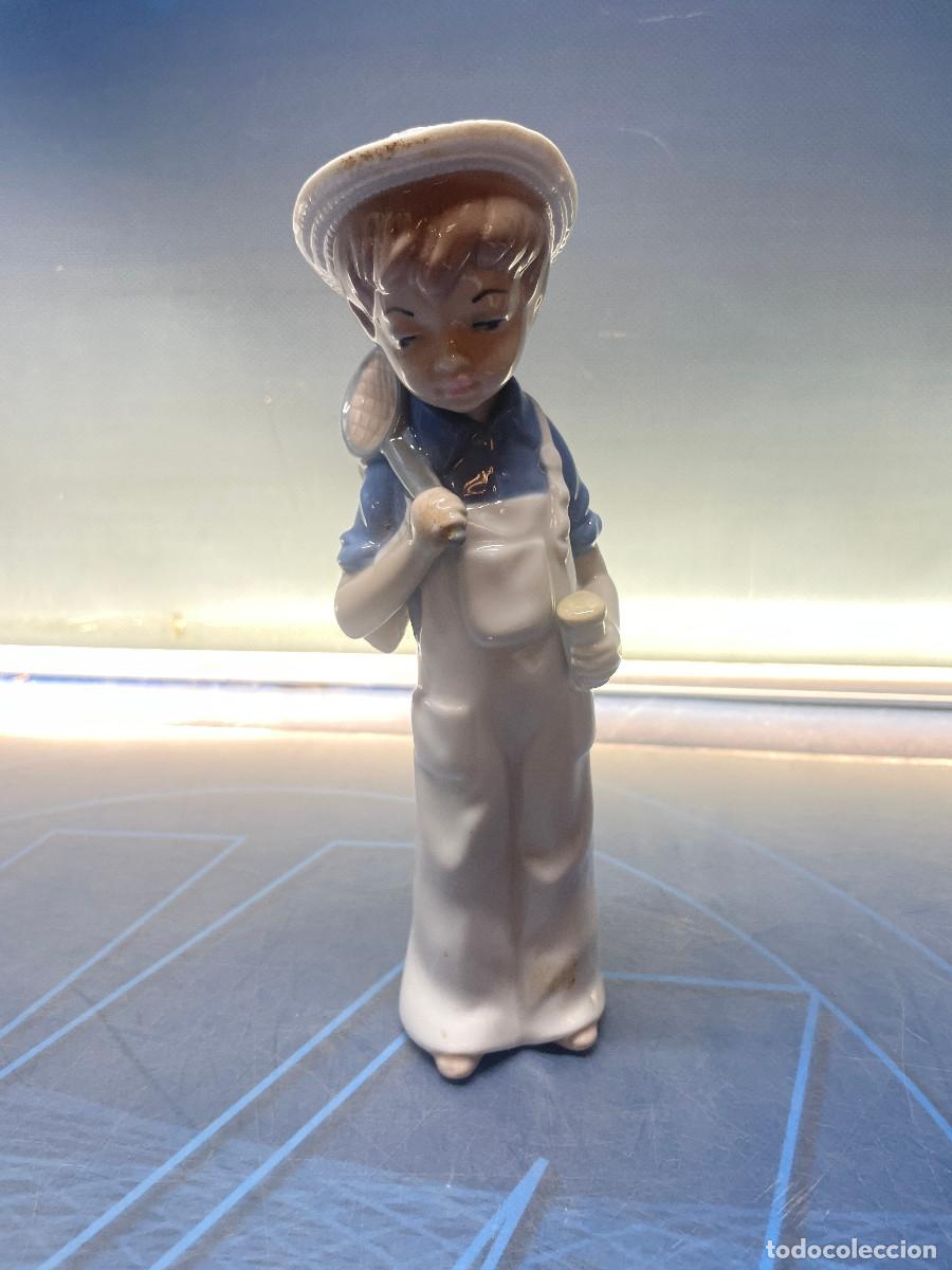 Antig&uuml;edades: Ni&ntilde;o recolector de mariposas, porcelana casades 21cm