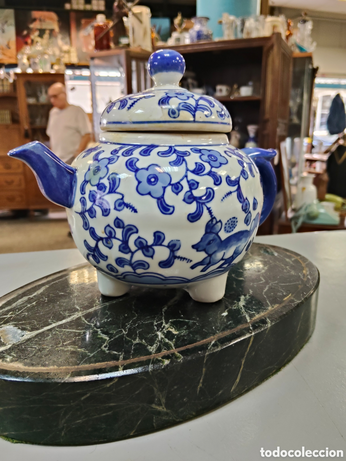 Antig&uuml;edades: Tetera china antigua de porcelana azul y blanca, conocida por su vibrante coloraci&oacute;n y dise&ntilde;o floral